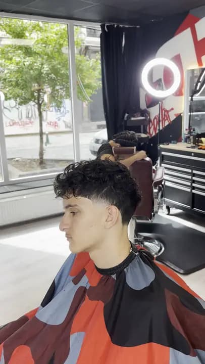 Cheveux bouclés sur les côtés dégradés